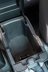 Empty car center console with black charger plug on textured surface