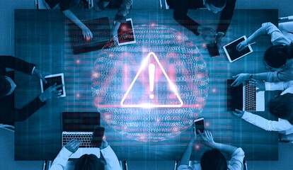 A diverse group of professionals collaborates in an office to analyze cybersecurity threats, surrounded by digital elements symbolizing data security risks and alerts. Gantry