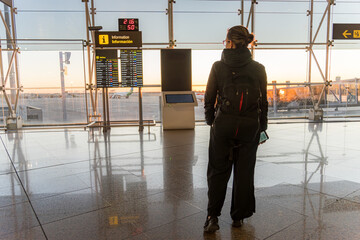 Traveler waiting in airport terminal during sunrise