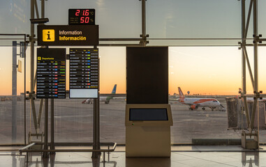 Airport departures area at sunrise showcasing flight info