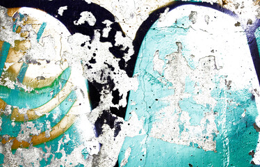 Muro con graffiti desgastado y pintura descascarada sobre concreto.