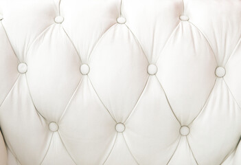 Obraz premium Tapizado en cuero claro con diseño capitoné en rombos y botones redondos, formando superficie acolchada.