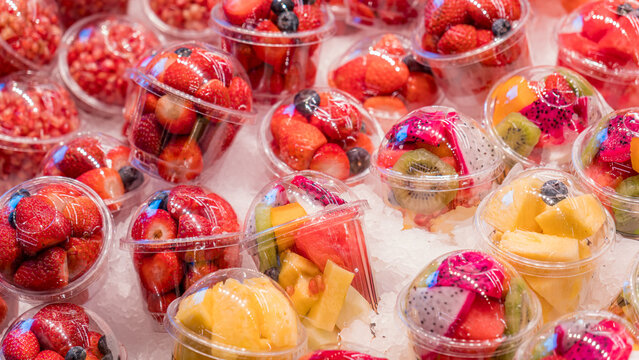 Fresh fruit cups on display at a vibrant market stall