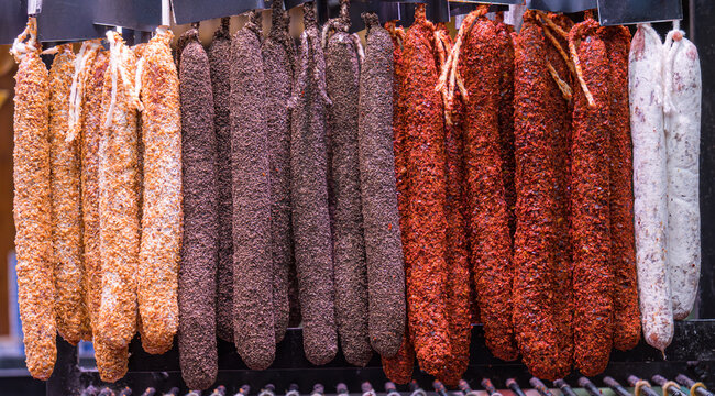 Colorful assortment of hanging sausages at the market