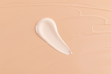 Creamy foundation sample on peach background