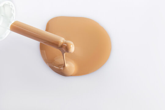Liquid foundation sample pouring onto white surface