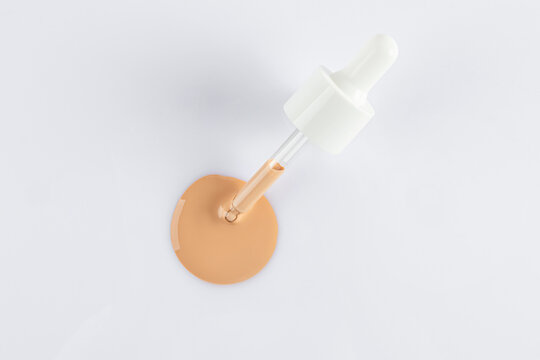 Liquid foundation sample with dropper on white surface