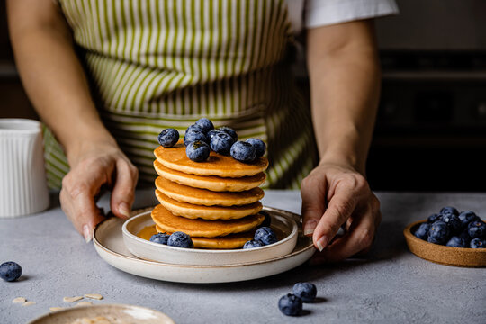 Woman with breakfast and fresh blueberries