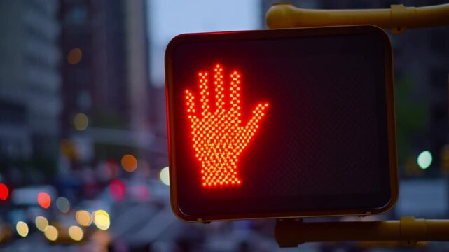 A bright red Don't Walk pedestrian signal illuminated in an urban setting, with city buildings visible in the background Stock Video