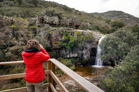 Woman admiring waterfall in Castilla La Mancha landscape