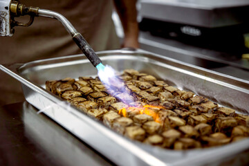 Culinary preparation of beef with flame torch technique