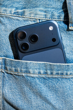 Smartphone in denim pocket with triple camera