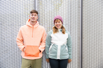 Siblings in cozy autumn outfits set against an urban backdrop