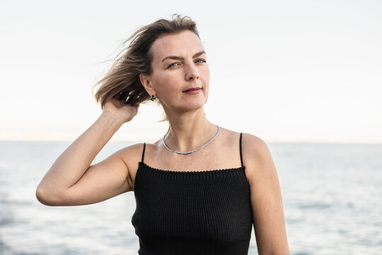 Woman with short hair at beachside on a cloudy day