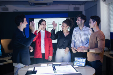 Diverse digital marketing and web development team celebrating success with a high five after a productive meeting. Successfully finished a complex UX UI project on creative AI application strategy