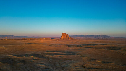 Naklejka premium A large rock sits in the middle of a vast, empty desert