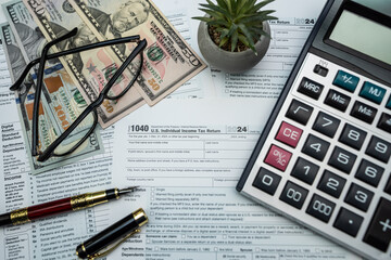 US dollar bills and form 1040 with glasses and calculator ready for 2026 tax processing