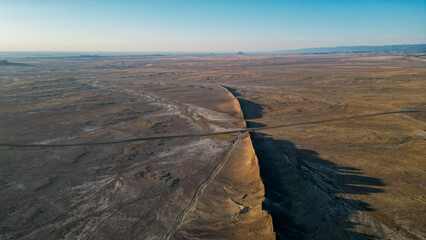 A large rock sits in the middle of a vast, empty desert