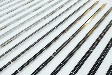 Renewable energy concept. Aerial drone view of solar panels power plant with sunlight in winter, Norway