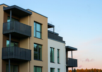 New modern apartment building exteriors in a residential area, with balconies and contemporary architecture.