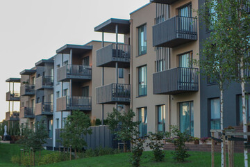 New modern apartment building exteriors in a residential area, with balconies and contemporary architecture.