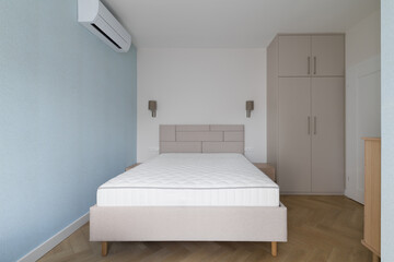 Modern small bedroom interior with beige bed and wardrobe