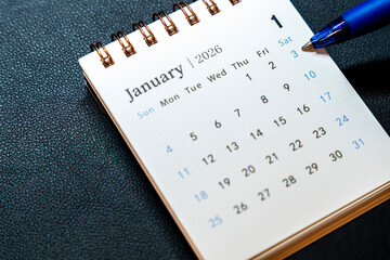 A close-up of a calendar page for January 2026, featuring the date 1 highlighted. A blue pen is poised over the date 3, indicating preparation for upcoming events.