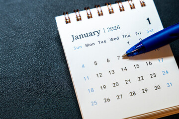 A close-up view of a calendar for January 2026, showing the first week of the month. A blue pen rests on January 7, indicating an important date to note.