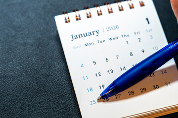 Close-up of a calendar page for January 2026, highlighting the date 25, marked with a blue pen. Represents planning and scheduling for the upcoming month.