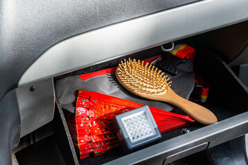 Car glove compartment with fan, brush, LED light, and strap.