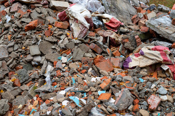 Pile of construction debris. Crushed, cracked construction waste in the form of bricks, cinder block fragments, and concrete rubble
