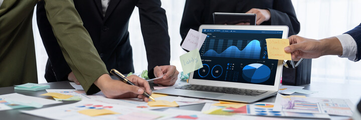 Analyst team use sticky note for creative and analytic brainstorm for business idea with BI data dashboard on laptop screen. Analysis financial data visualization tech for marketing strategy. Prodigy