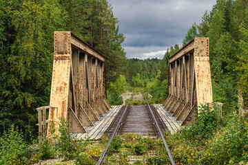 Abandoned railway bridge tracks through Sweden Lapland forest