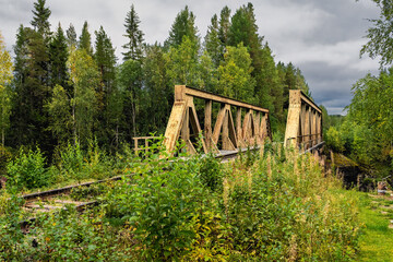 Old railway bridge spanning lush forest in Lapland nature