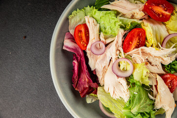 Salad chicken meat and vegetables tomato, green leaf lettuce, onion natural product tasty snack fresh delicious gourmet food background on the table rustic top view copy space keto and paleo diet