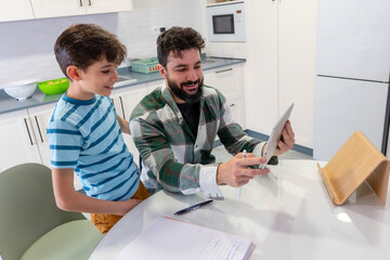 father and son doing homework and using tablet at home