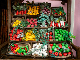 An assortment of plastic vegetables and fruit in baskets in a market 