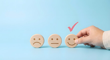 Hand Selecting Smiling Wooden Face Icon for Customer Satisfaction or Feedback Concept
