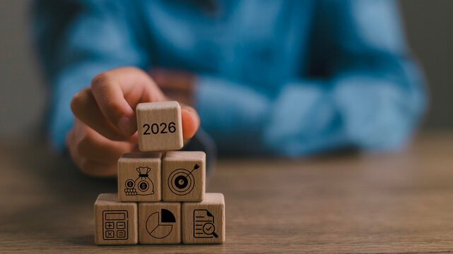 2026 financial, budget planning and management concept. Wooden blocks displaying the year 2026 and a financial icons, symbolizing financial, budget planning, saving money, investment, economic growth.