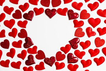 Red heart shapes arranged in a larger heart outline on white background, creating copy space, for Valentines Day or love and wedding concept.