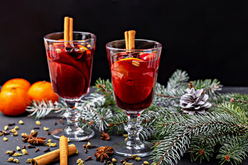Mulled wine. Festive mulled wine served in elegant glasses, garnished with cinnamon sticks and fresh fruits, surrounded by pine branches and spices, creating warm and inviting holiday atmosphere