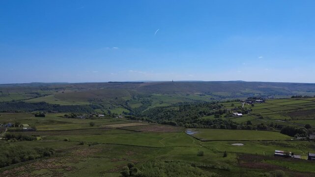 panoramic aerial drone view of west yorkshire landscape near hebden bridge showing jumble hole clough and stoodley pike monument surrounded by meadows and moorland