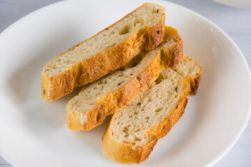 Fragrant loaf with sesame and buckwheat flour cut on a white plate. Healthy bread for breakfast