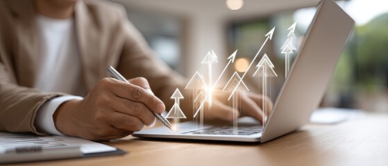 A person is focused on typing and reviewing financial reports on a laptop, with charts and a calculator nearby in a well-lit workspace