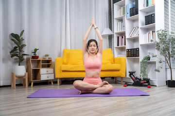  Serene Yoga at Home: A woman finds peace and well-being as she gracefully practices yoga on a mat within the cozy ambiance of her living space, embodying mindfulness and balance.