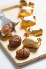 Wrapped Chestnut Candy on Wooden Board