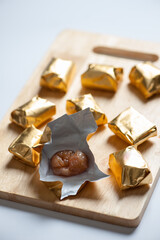 Wrapped Chestnut Candy on Wooden Board