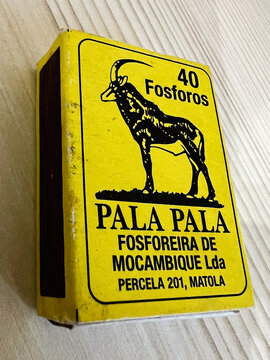 Yellow warning sign with a goat silhouette and Mozambican text from a fosforos mine site