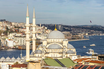 Obraz premium Scenic view of Istanbul along the Bosphorus featuring a monumental Ottoman mosque with twin minarets, dense urban hillside, blue waterway with boats, and bright daylight atmosphere for travel and cult