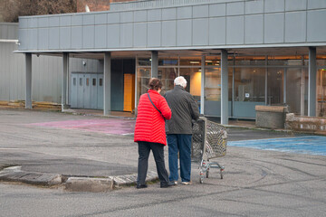 deux personnes &acirc;g&eacute;es pousse le caddy